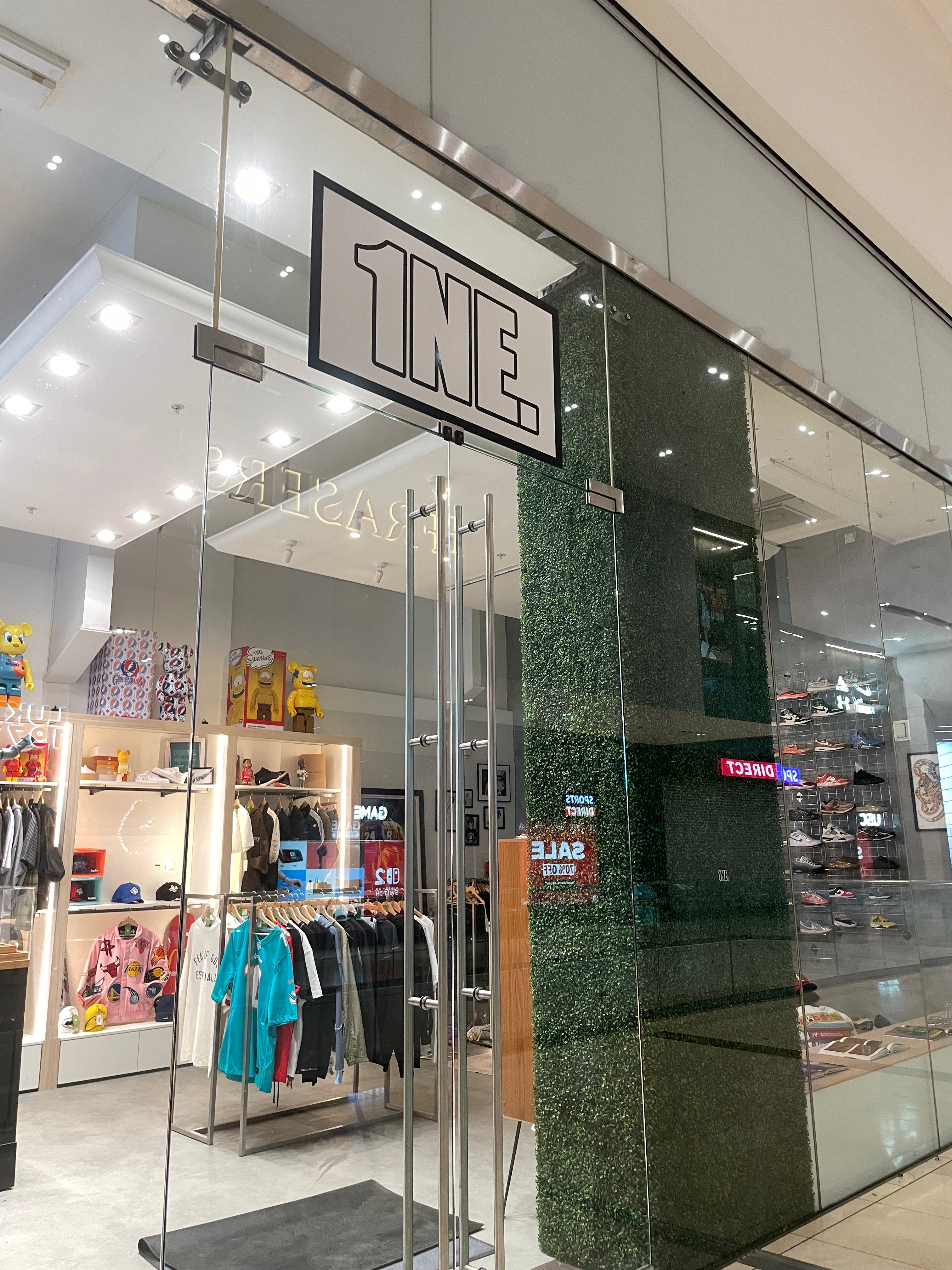Storefront with '1NE' branding inside a shopping mall